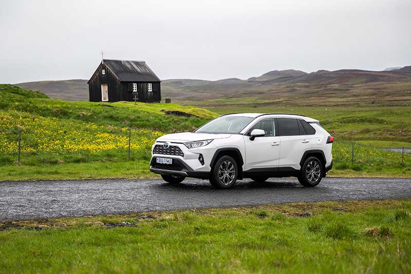 4x4 SUV from Holdur car rental in Iceland driving past black old church