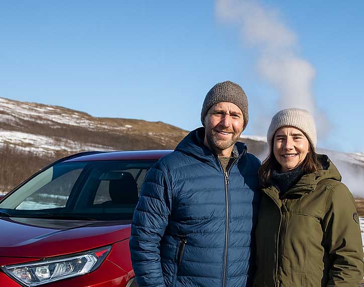 Happy couple driving in Iceland in March