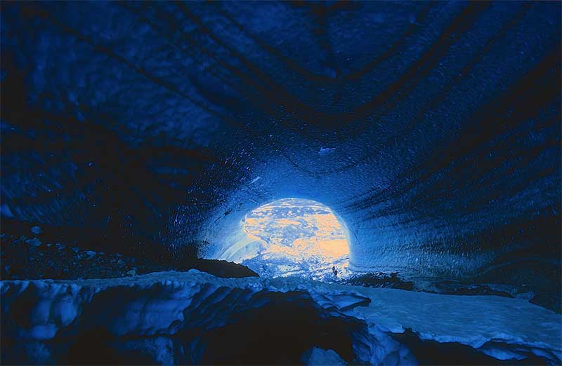 Tourists exploring long Icecave in Iceland