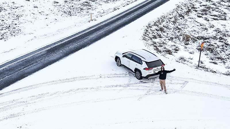 Snow-covered road near Reykjavík during Iceland’s winter, driven safely with a Höldur rental car.
