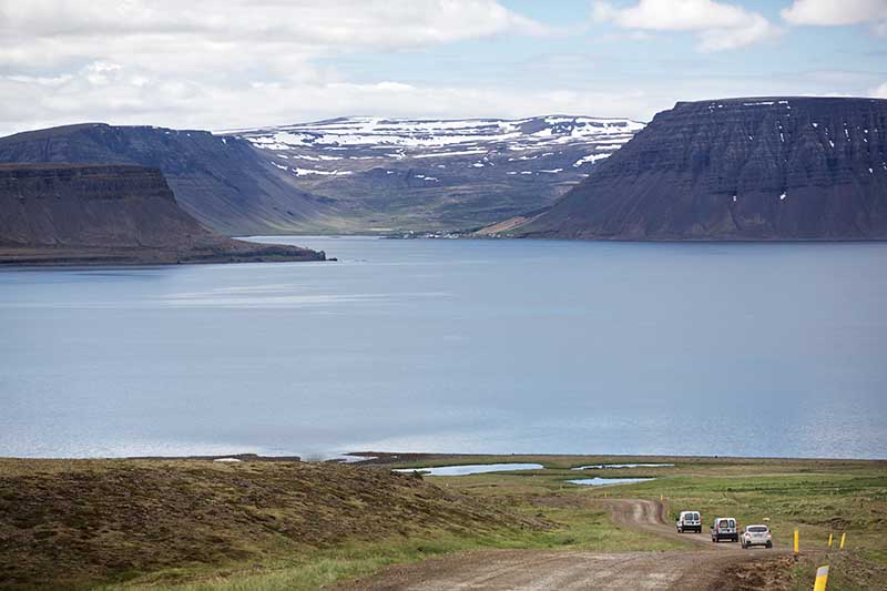 Cars driving on gravel road on Route 60 in Westfjords Iceland