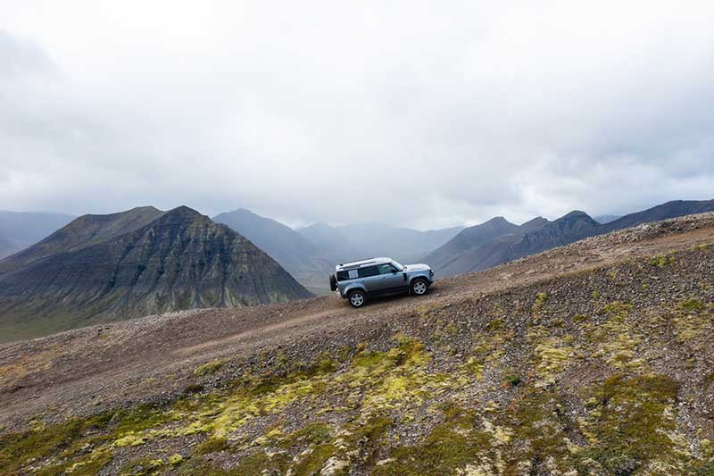 Land Rover Defender 4x4 driving on gravel road in Westfjords Iceland
