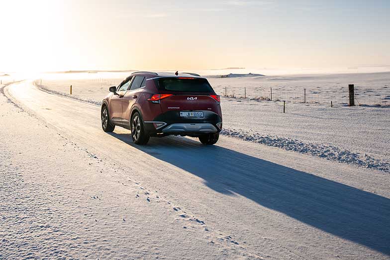 Kia Sportage driving on Icelandic winter road during golden hour