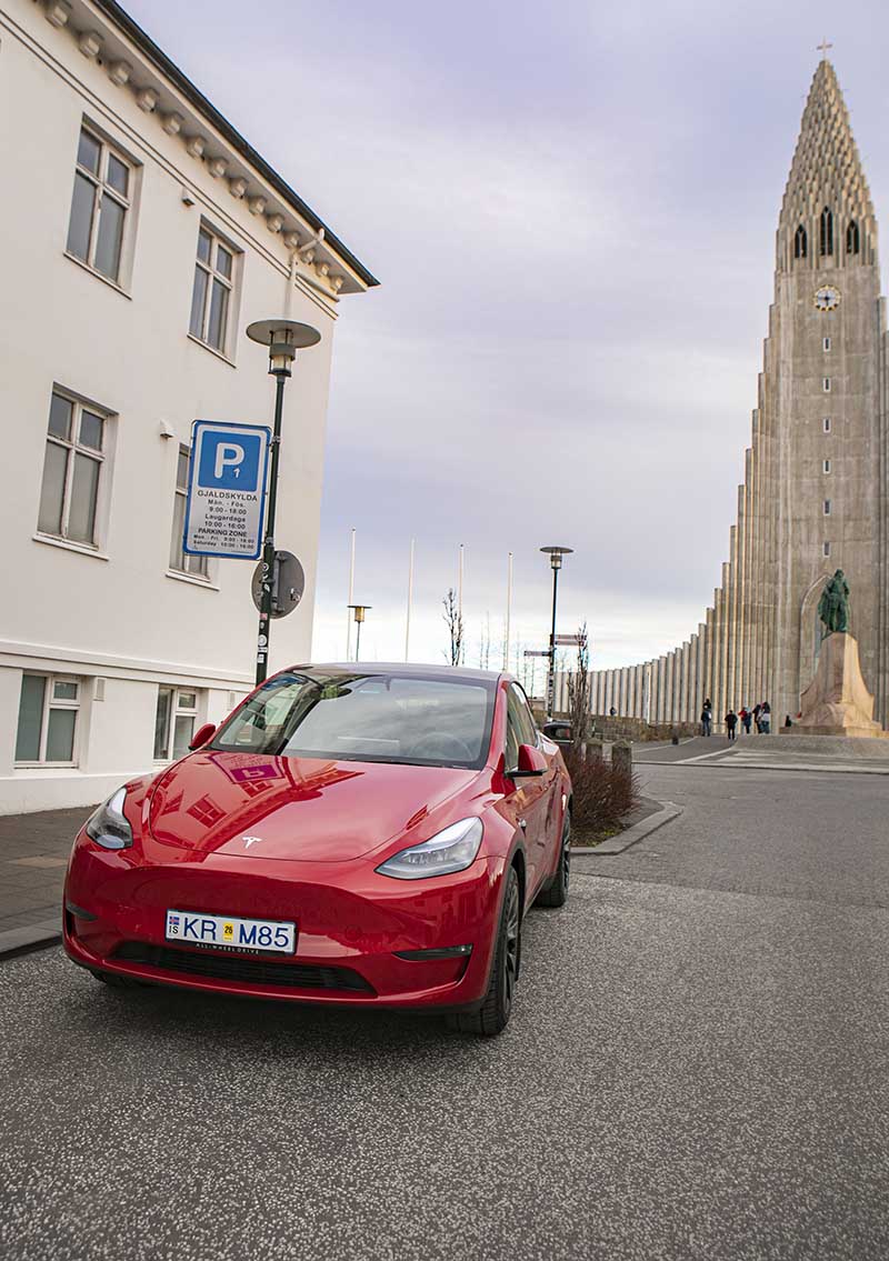 Tesla from Holdur Car Rental parked at Skolavordustigur in front of Hallgrimskirkja Church