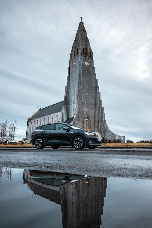 Volkswagen ID.4 GTX driving in front of Hallgrimskirkja church in downtown Reykjavik Iceland