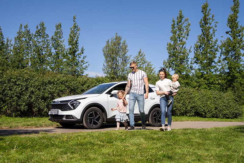 Family and a white Kia 4x4 SUV from Holdur Car rental in Iceland