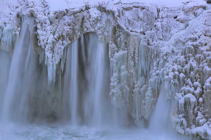 Partly frozen waterfall in Iceland South Coast